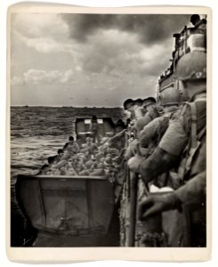 American invaders clamber from a Coast Guard LCI into a la…