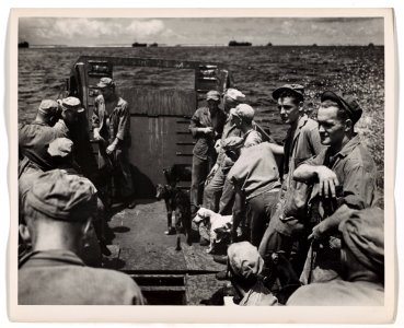 Aboard a Coast Guard-manned landing barge, Marines and the…