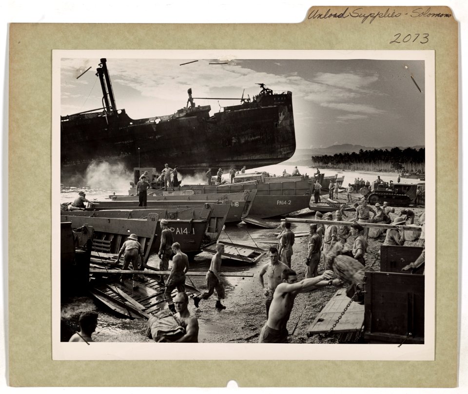 U.S. Coast Guardsmen and Marines unload supplies in the sh…