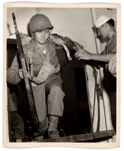 A U.S. Coast Guardsman extends a helping hand to a Marine*…