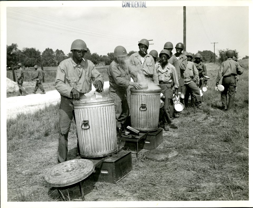 African-American troops line up for a meal at a U.S. Army …
