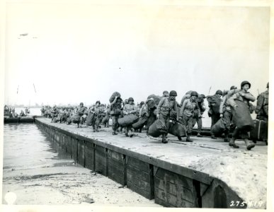 SC 275419 - At hightide troops debark from LCT on to cause…