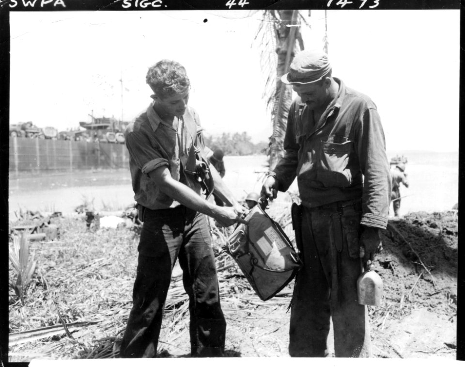 SC 190496 - Two U.S. Navy men inspect a Japanese Parachute…
