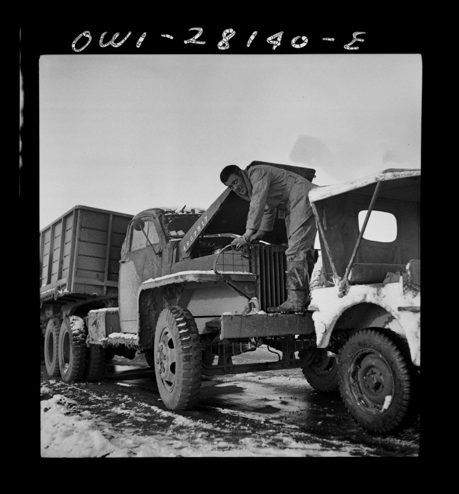 A truck driver checking the oil. He is with a United State…