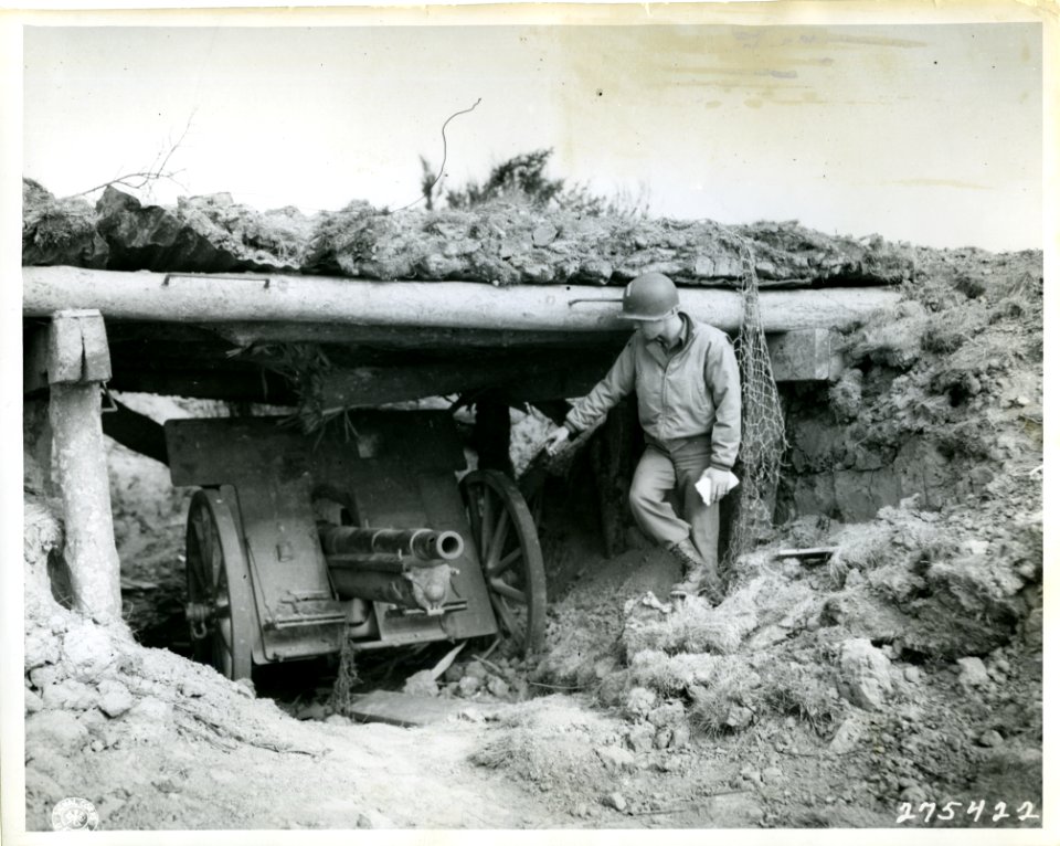 SC 275422 - An American soldier points to a 75-mm German g…