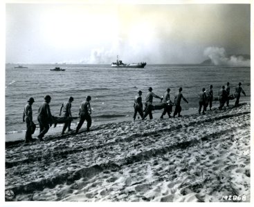 SC 192868 - The wounded are carried back to the beach to b… photo