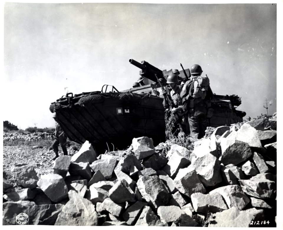 SC 212184 - Flanked by infantrymen, a gun-carrying DUKW ro…