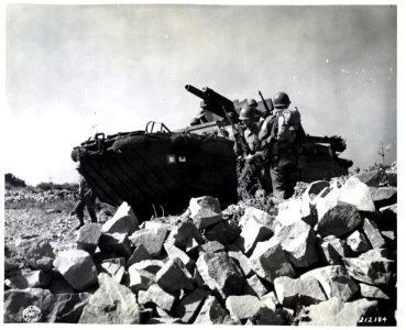SC 212184 - Flanked by infantrymen, a gun-carrying DUKW ro…