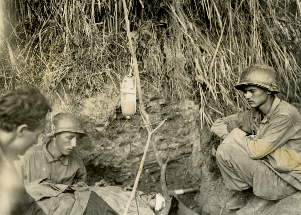 SC 265138 - A wounded soldier is given blood plasma by med…