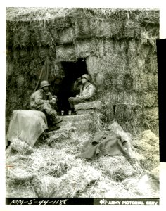Digging out a few bales of hay from the stack, Pvt. Robert… photo