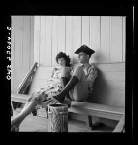 A serviceman with his date outside of the entrance to Kans…