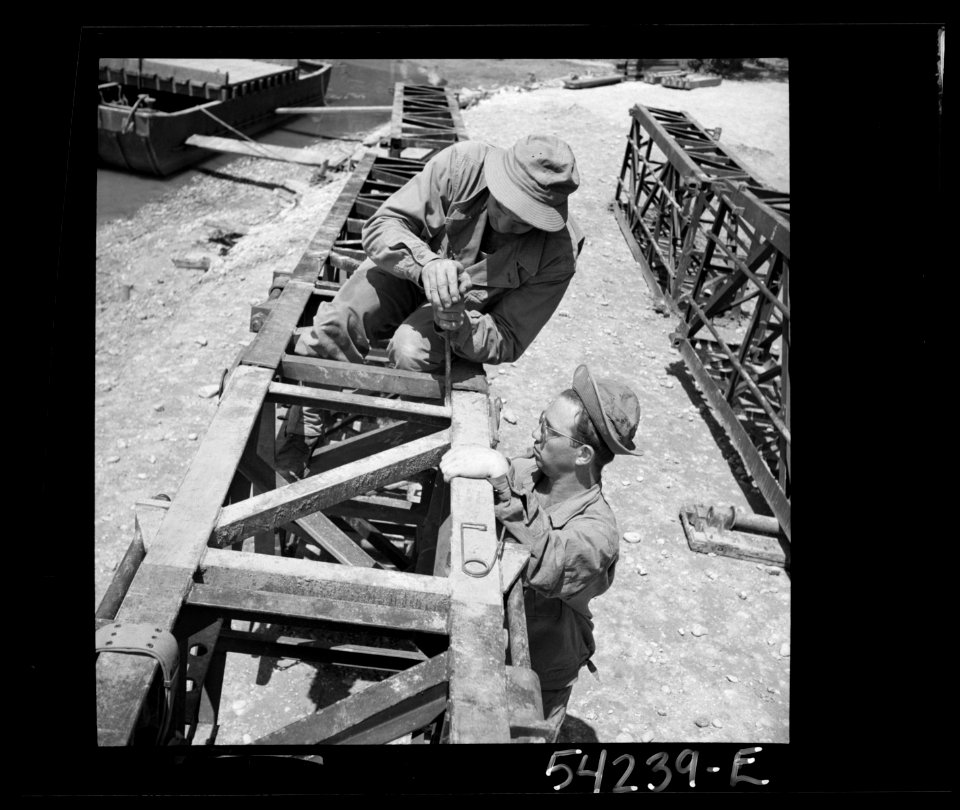 United States Army engineers constructing a bridge or a pi…