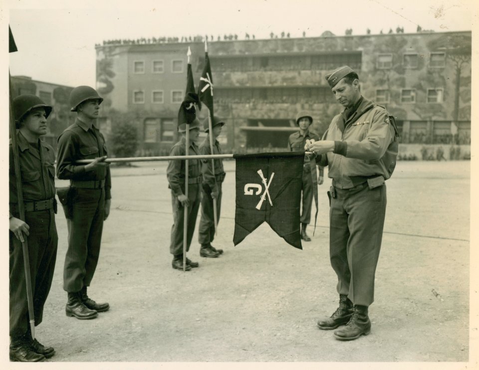 Lt. General Mark W. Clark pins a battle streamer on the gu…