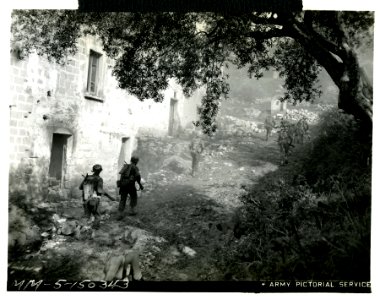 Alert Ranger riflemen advancing past a house on the Italia… photo