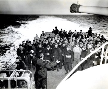 Enlisted men bow their heads as they follow the prayers of…