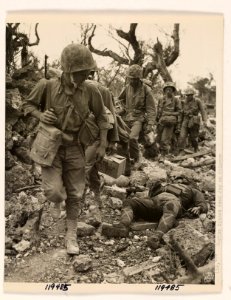 Advancing Marines sidestep as they pass the body of a Jap …