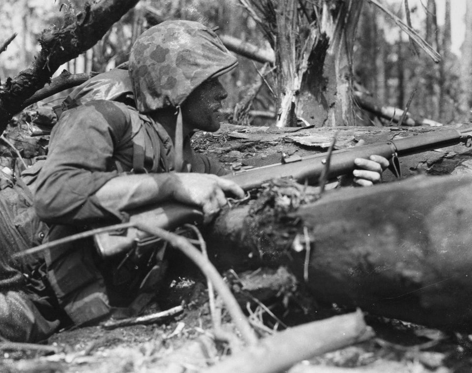 Marine PFC Kenneth G. Crowley takes cover behind a fallen …