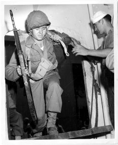 American soldiers boarding a Coast Guard transport somewhe…