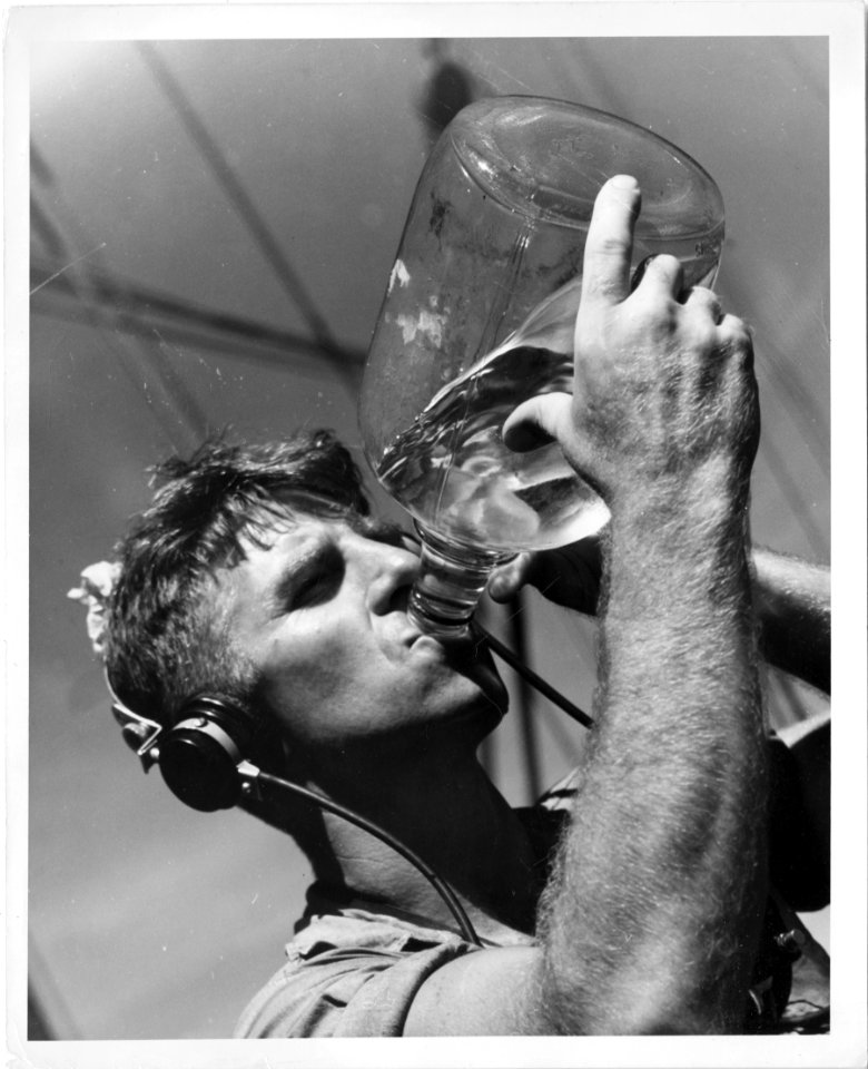 A U.S. Coast Guardsman quenches the thirst worked up while…