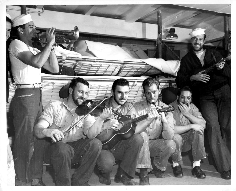 Six bearded Coast Guardsmen play instruments during off-wa…