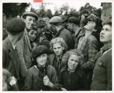 French civilians fraternize with the American soldiers who…