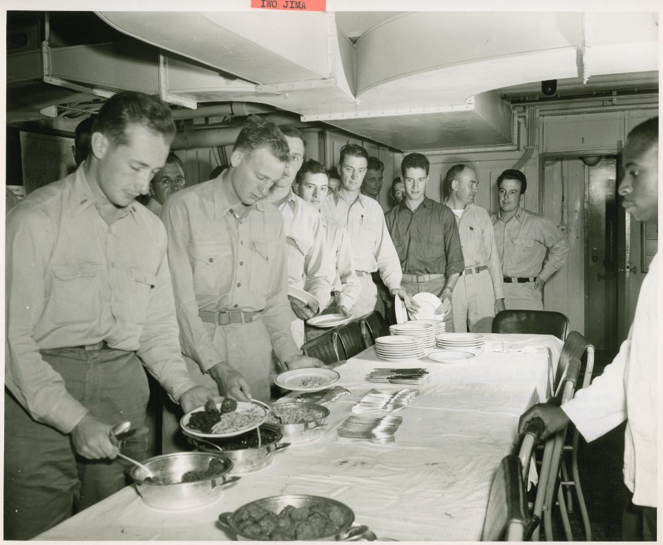 Chow is served cafeteria style aboard a Navy warship en ro…