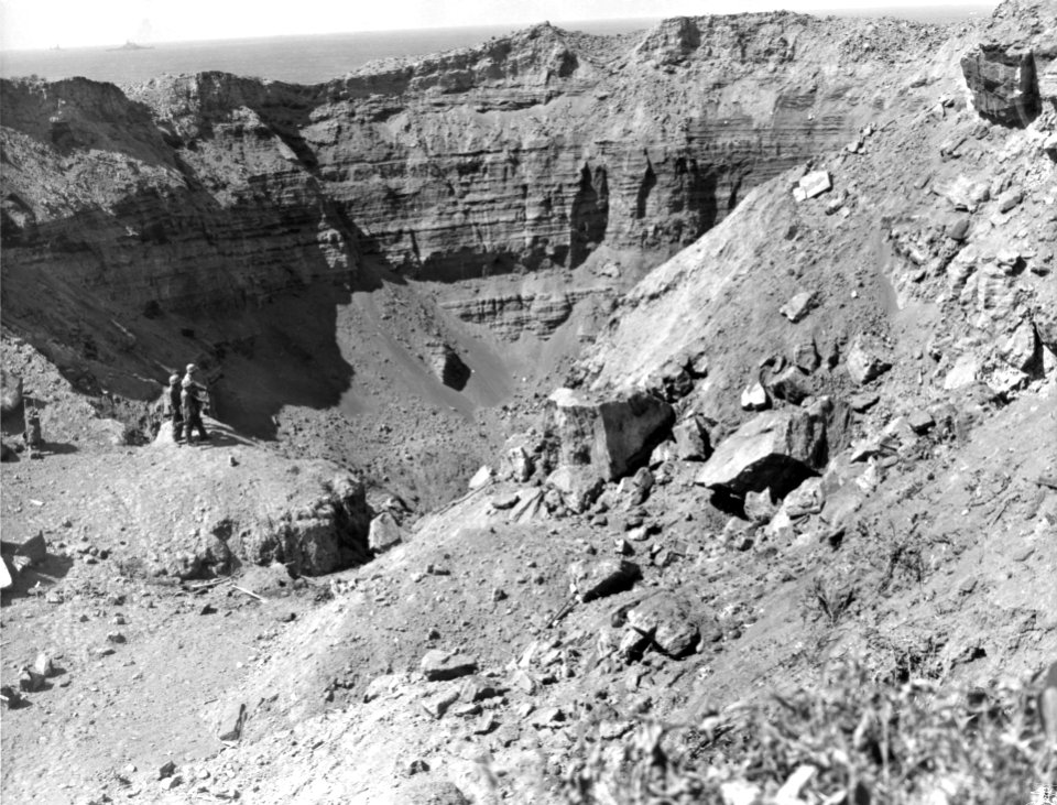 Three Marines survey a sulphur pit on Iwo Jima after high …