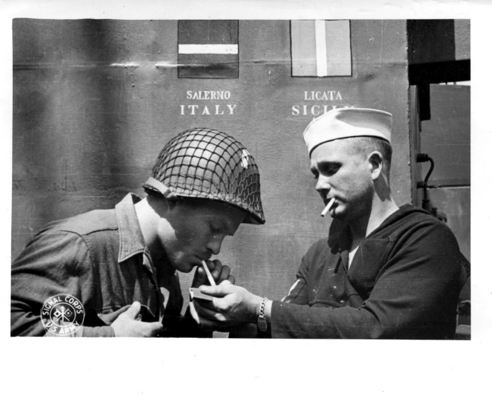 SC 190505 - An American soldier gets a light from a sailor…