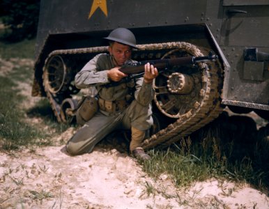 A young soldier of the armored forces holds and sights his…