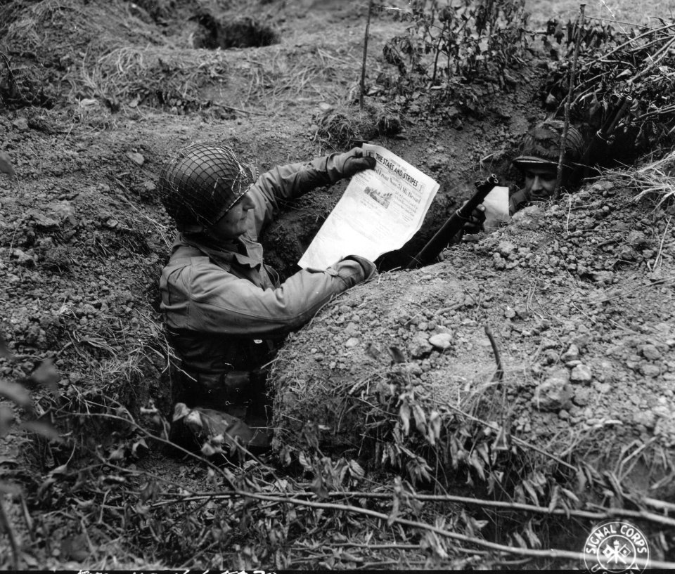 SC 190598 - In the shelter of their foxhole, two GIs read …