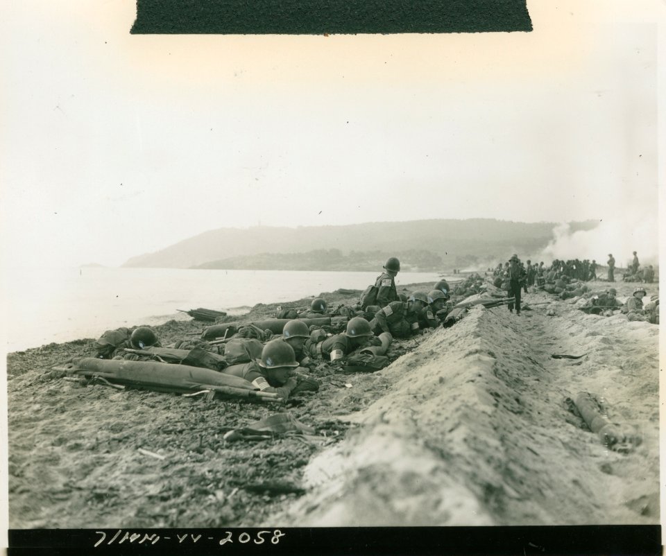 American medics and MPs of the 7th Army hugging the beach …