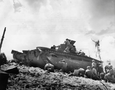 1st Division Marines rest behind the cover of an LVT at Pe…
