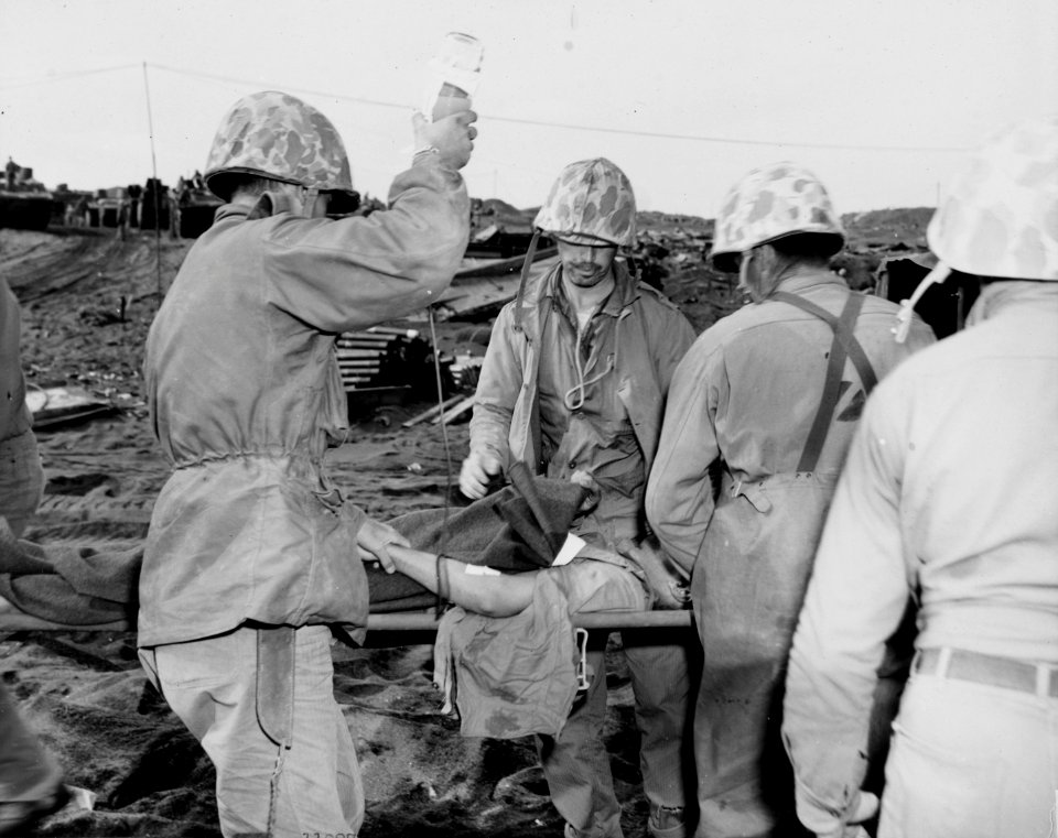 A wounded Marine receives a blood transfusion behind the l…