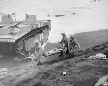 Three Leathernecks carry a wounded comrade to an evacuatio…