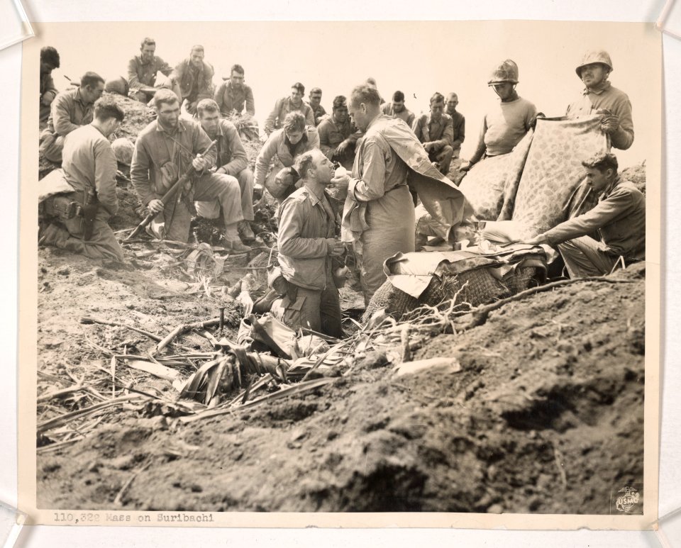 Heads bowed in prayer, Marines attend Holy Mass on the sum…