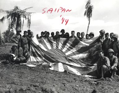 Marines pose with a Japanese flag they captured on Saipan.…