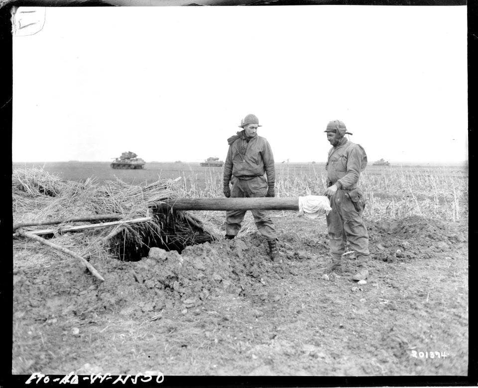 SC 201374 - American soldiers inspect dummy gun left by th…