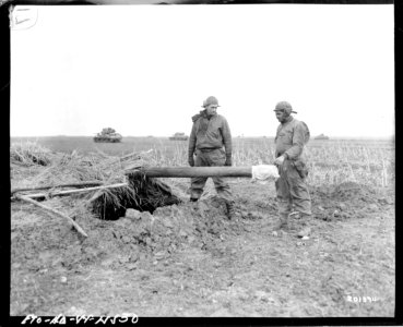 SC 201374 - American soldiers inspect dummy gun left by th… photo
