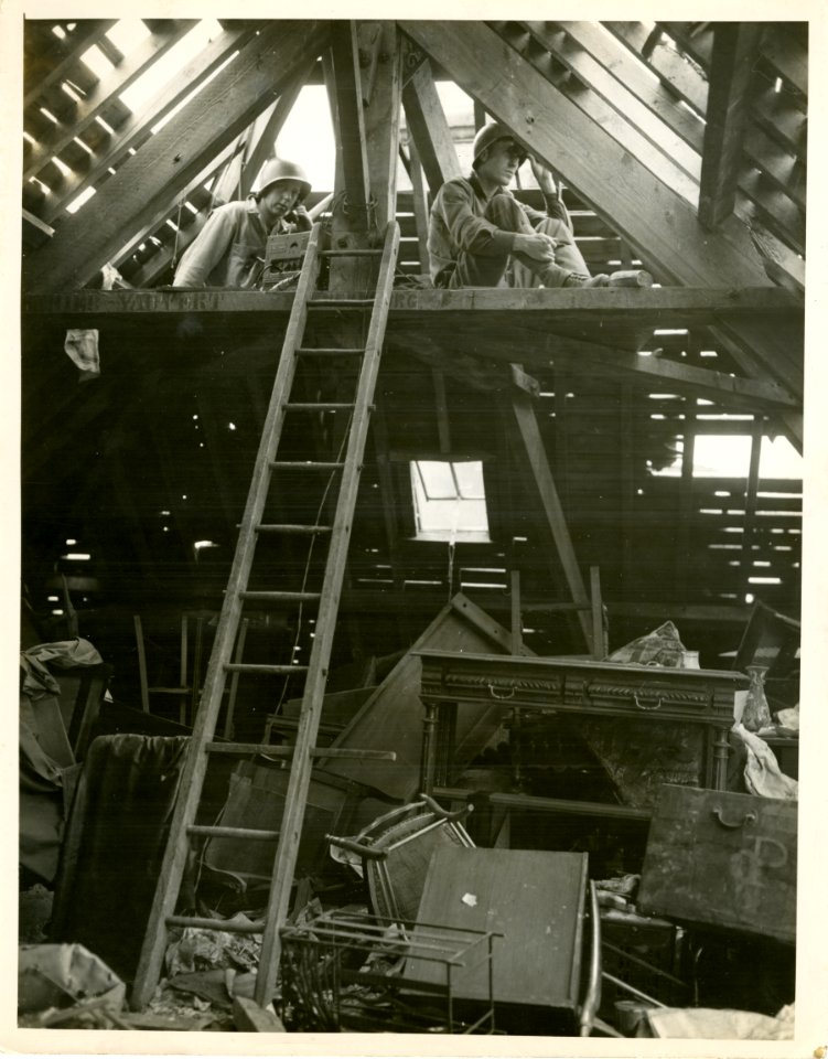 Soldiers watch for enemy aircraft through the damaged roof…