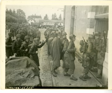Rain-soaked troops of 2nd Bn (15th) Inf. file into buildin… photo