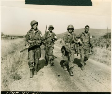 Le Muy, France. Paratroopers move along dusty country road…