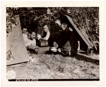 SC 349542 - GIs listen to the radio and eat chow in front …