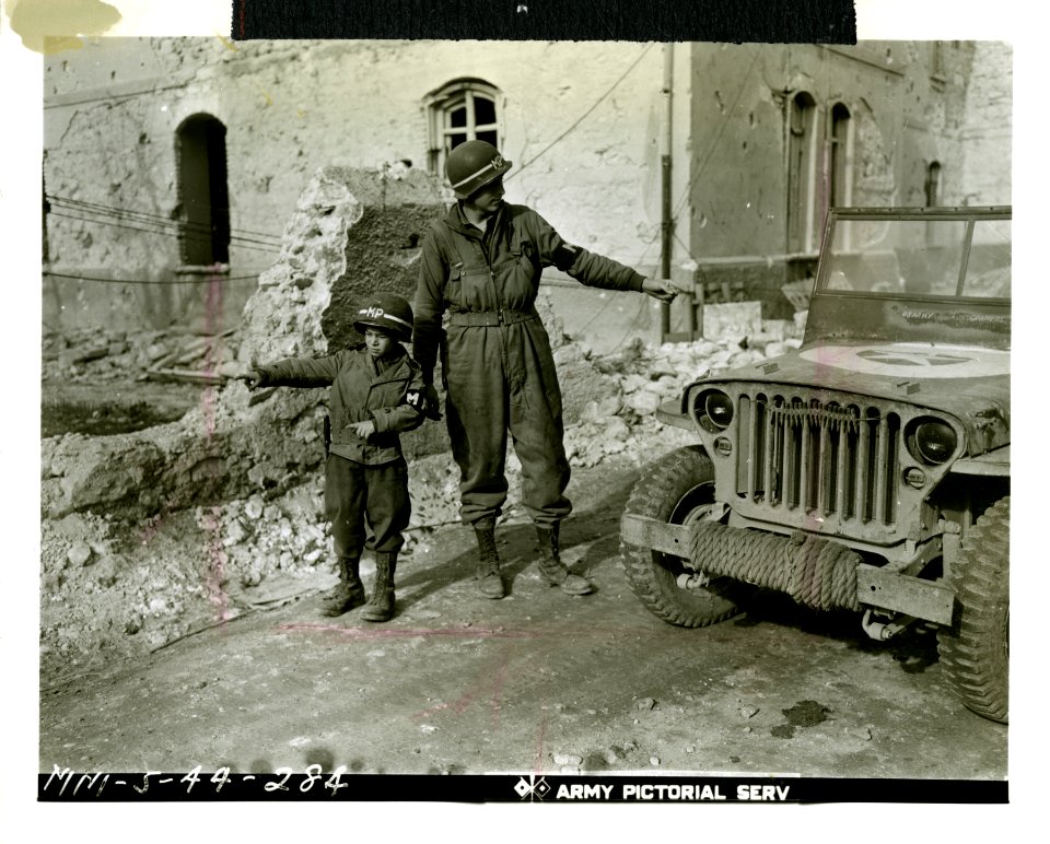 MP. Pvt. Mahlon Smith of Phoenixville, PA., is assisted in…