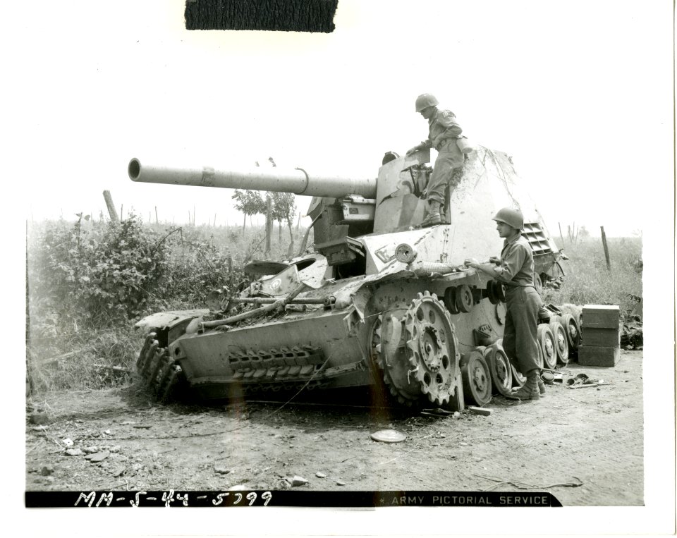 Two American soldiers examine German self-propelled gun kn…