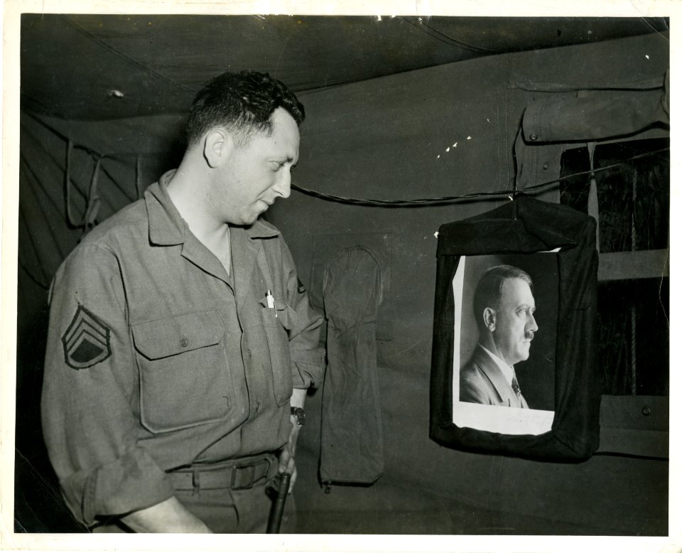 S/Sgt Harry Siegel finishes draping a photo of Der Fuhrer …
