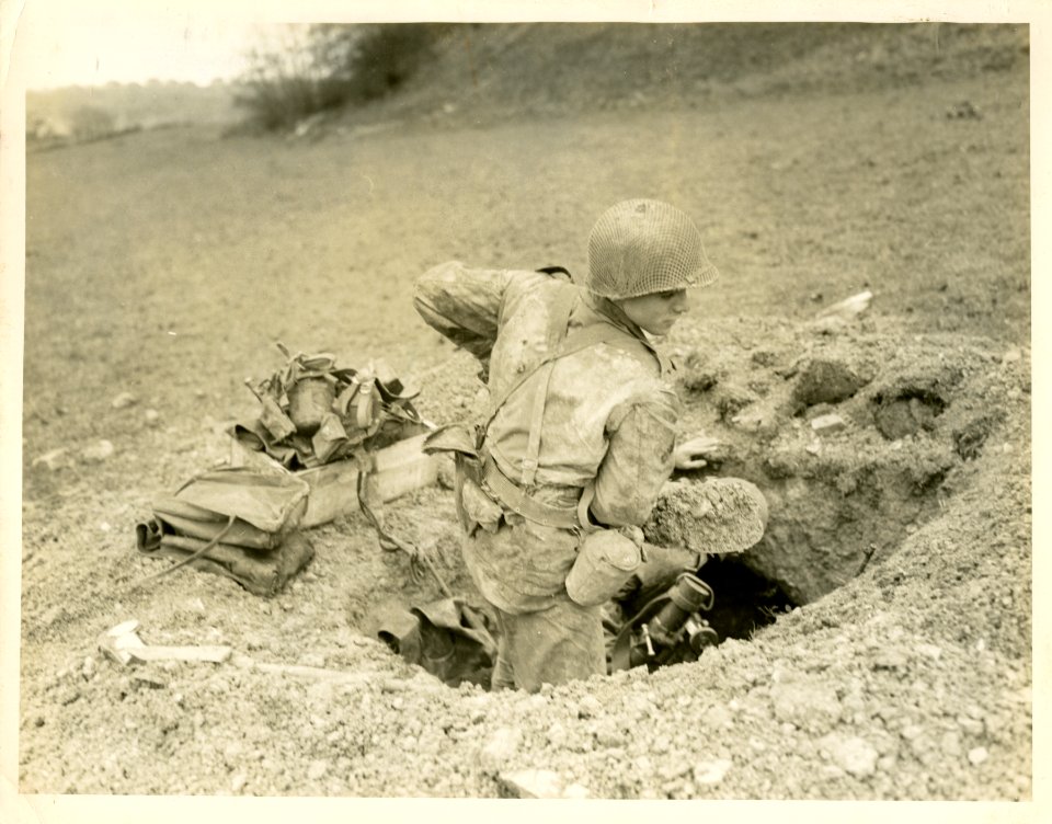 A mortarman of the 17th Inf., 12th Armored Division, digs …