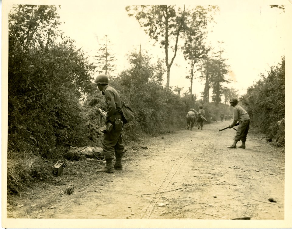GI infantrymen are careful as they march along the road to…
