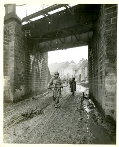 American infantrymen advance beneath railroad underpass ea…