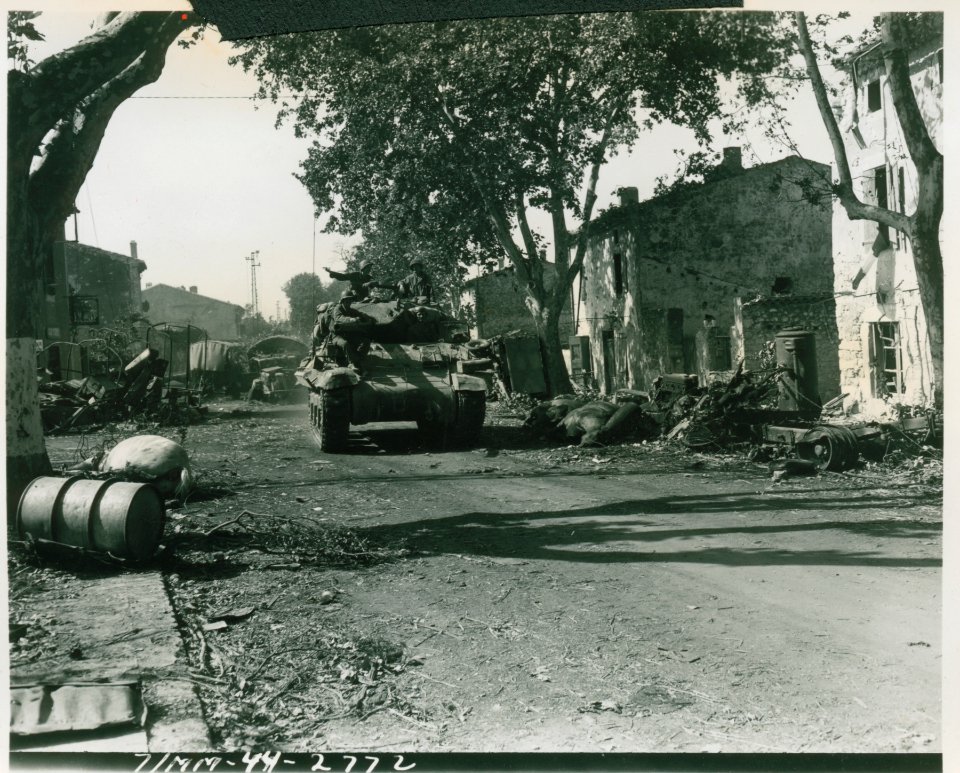 Seventh Army tank passes destroyed German convoy littering…
