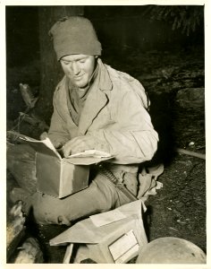 A Christmas package is opened by Pfc. Joseph C. Ray, of Ow… photo